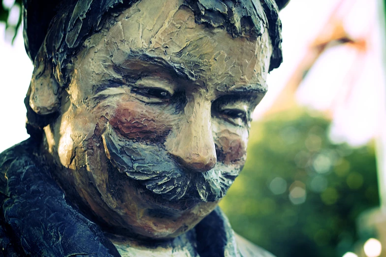 a statue is sitting outside with shaving on his face