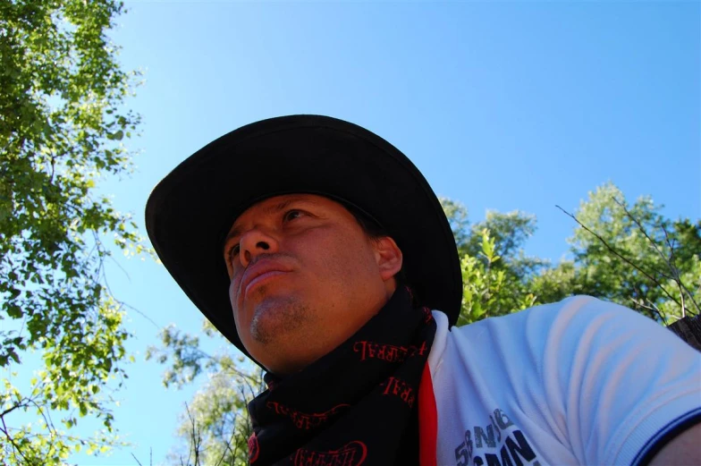 a man with a hat and scarf stares up into the sky