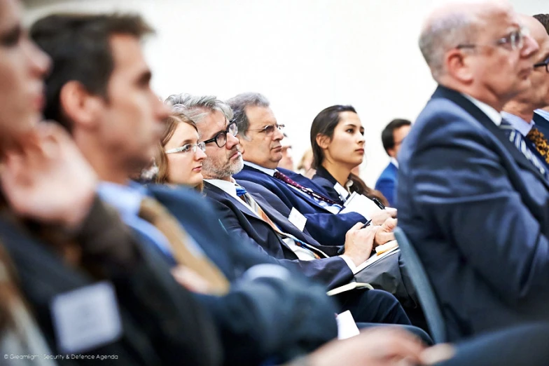 a group of people sitting in a row at a ceremony