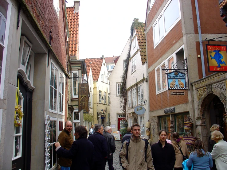 people walking down a small street past houses