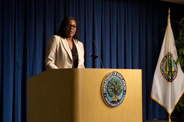 a person in a suit standing at a podium