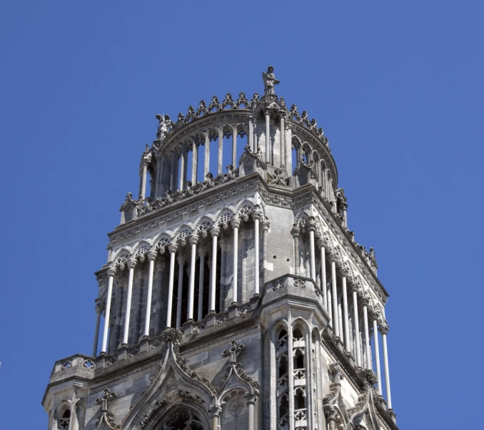 a tower top with a clock and a blue sky in the background