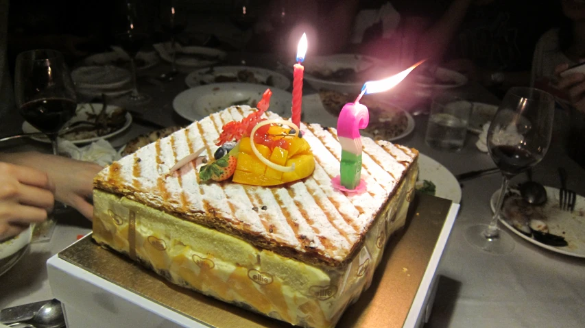 a cake with lots of candles on it sitting in the middle of a table