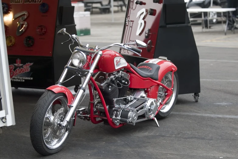 a red motorcycle sits parked in front of a food truck