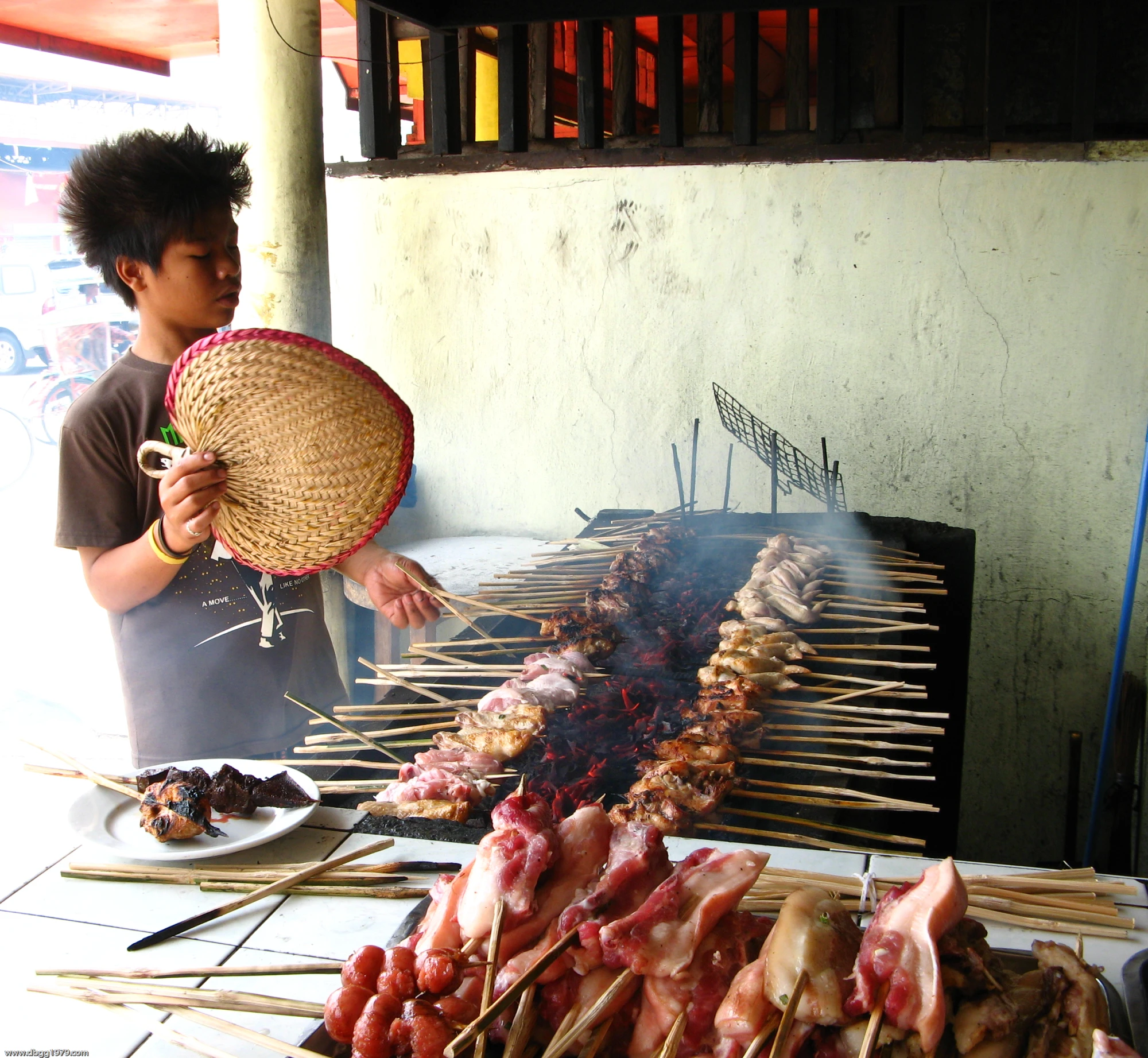 a man is cooking meat on skewers outside