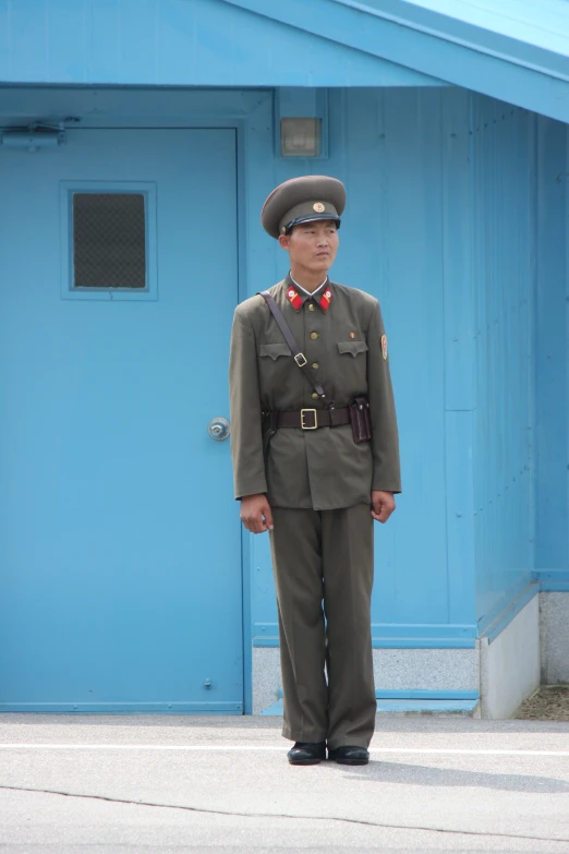 the uniformed man stands in front of a building