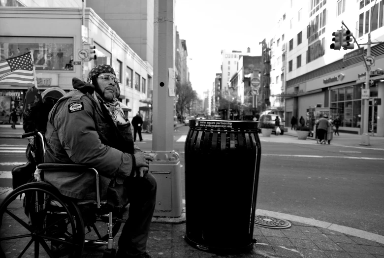 a man sitting in a wheel chair on a sidewalk