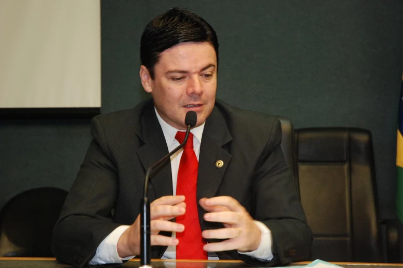 a man wearing a suit and tie sitting at a table