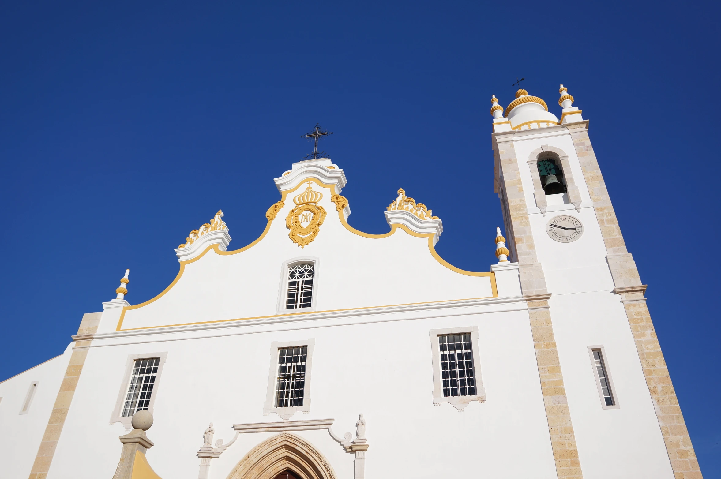 a white church with gold details on its roof