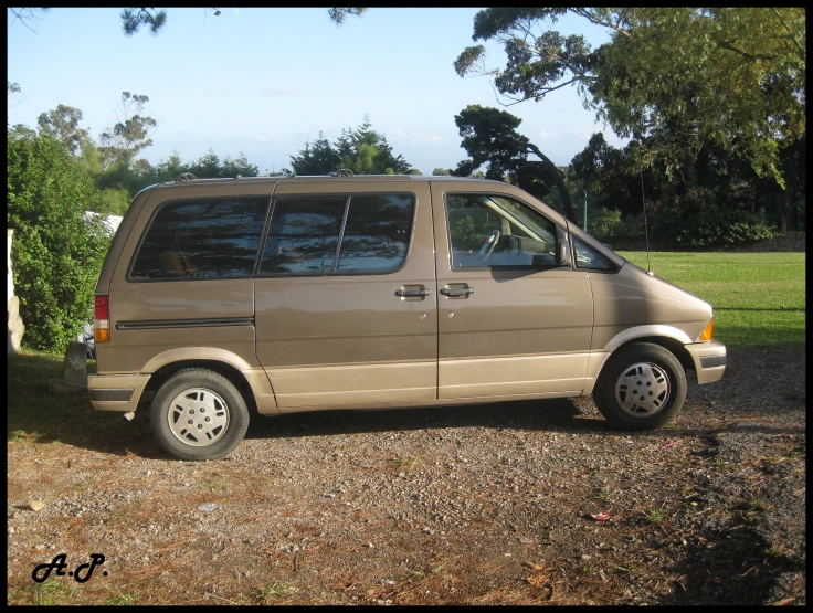 there is a tan van parked in the field