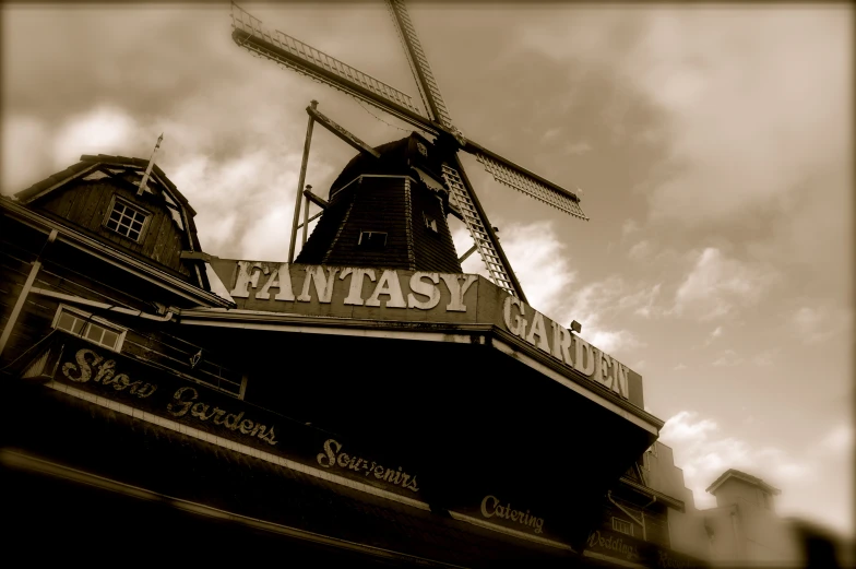 an old fashioned windmill is next to the restaurant