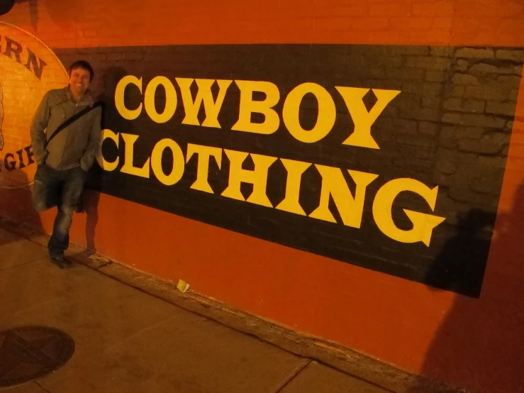 a man leaning on a sign outside a building