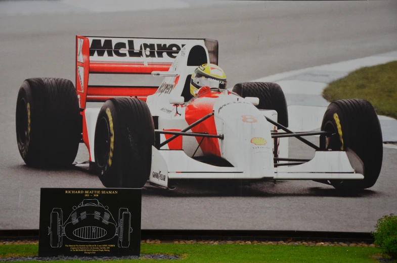 a painting on the side of a building showing a man driving a racing car