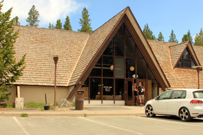 people outside the front entrance to a wooden building