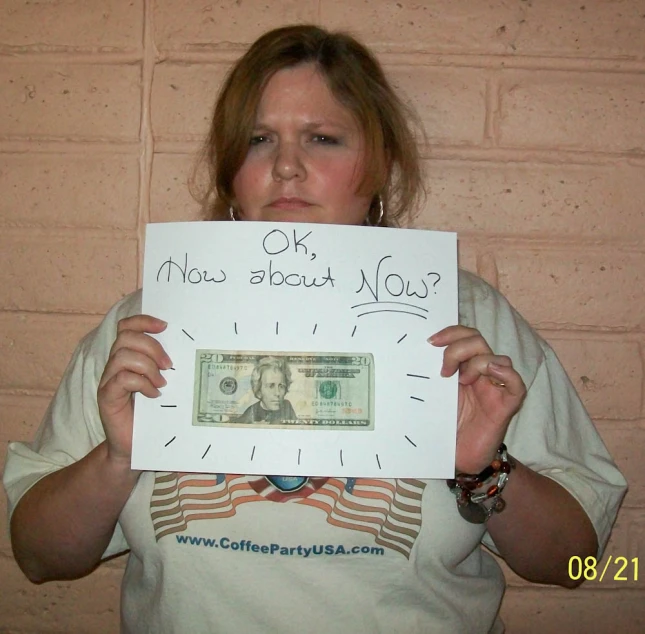 a woman holding up a sign in front of her face