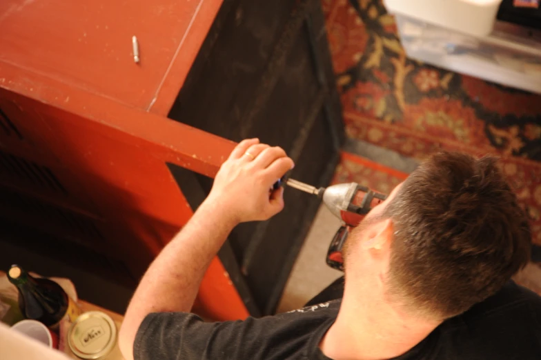 a man is fixing an area rug on a red bench