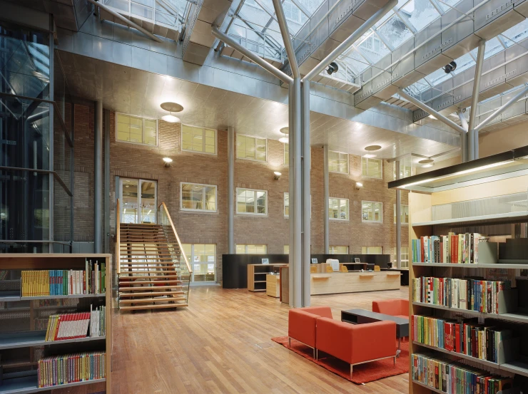 an open liry area is surrounded by wooden floors and skylights