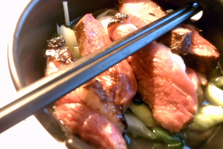 closeup of a bowl of soup with chop sticks resting on top