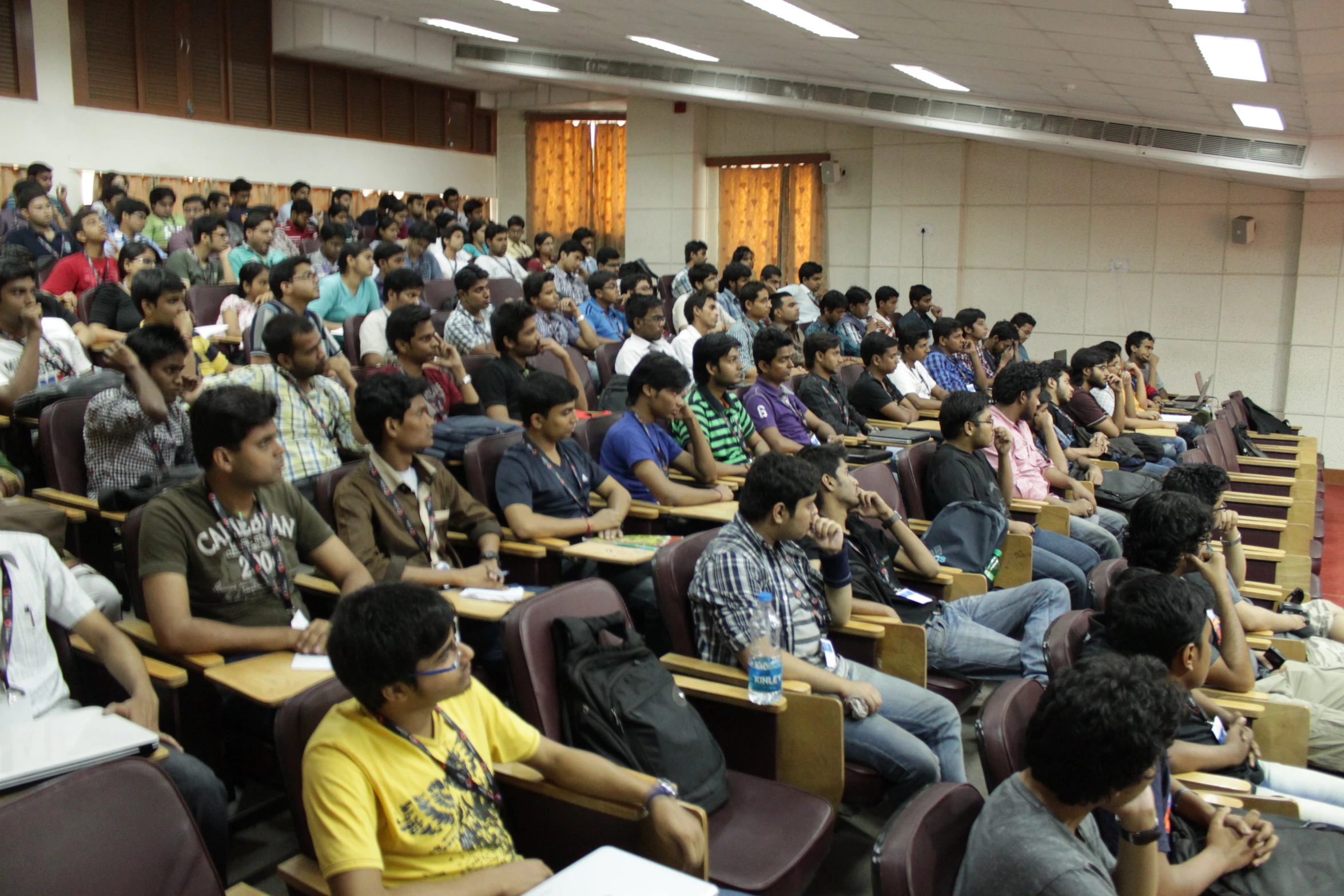 a large group of people sitting in chairs with cell phones in their hands