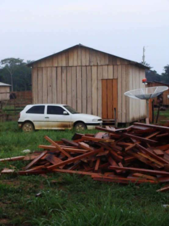 there is a car that is parked next to a barn