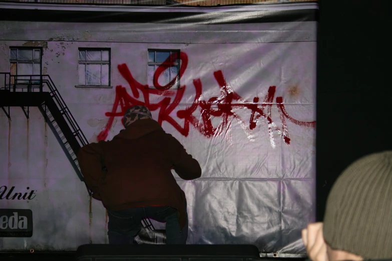 a man that is standing next to a sign with writing