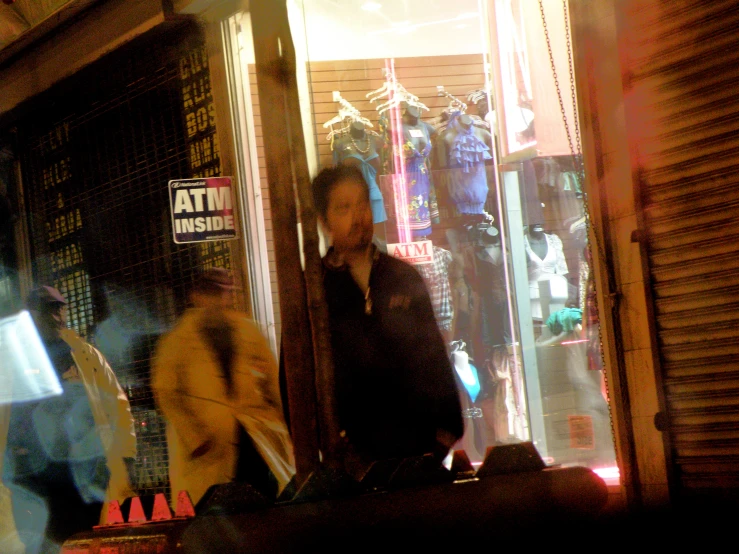 a man in the doorway of an art shop at night