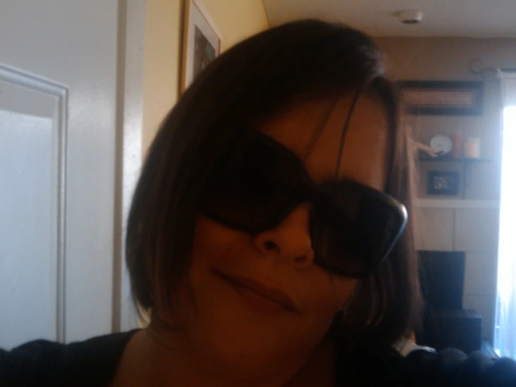 a woman is wearing sunglasses and is posing for a camera