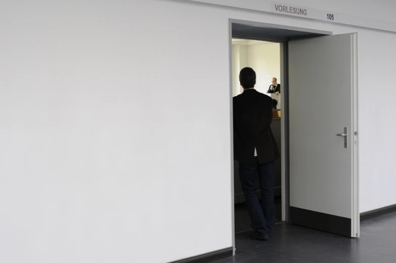 a man is entering through the hallway to another person