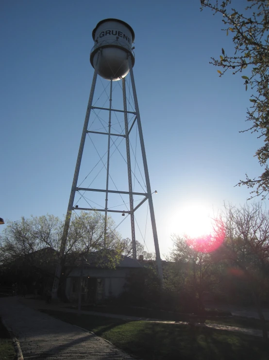 a tall water tower sitting next to a lush green tree