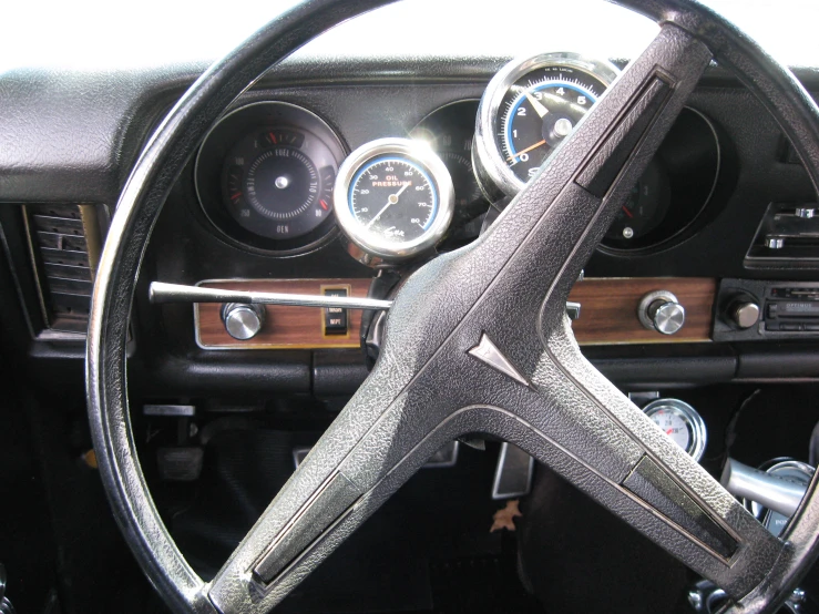 a dashboard on an older model car that has a clock and various gauges