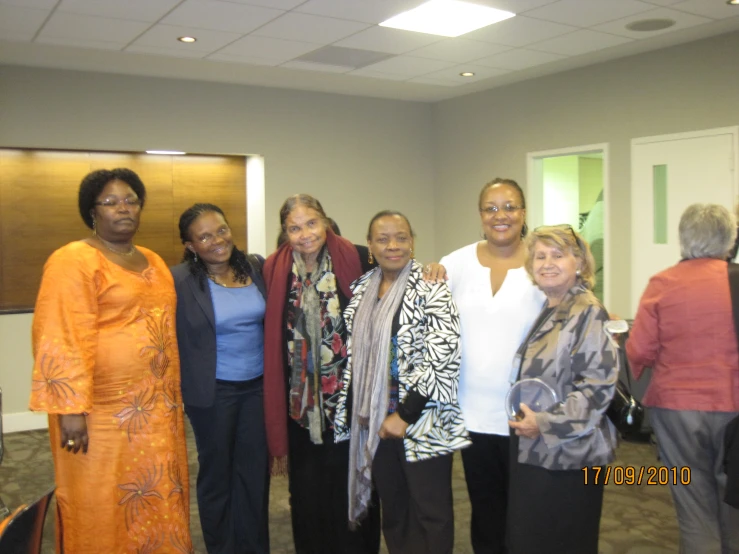 several ladies posing for a picture in a conference room