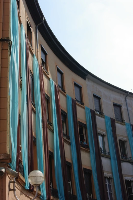 multicolored striped curtains hang from the windows of an apartment building