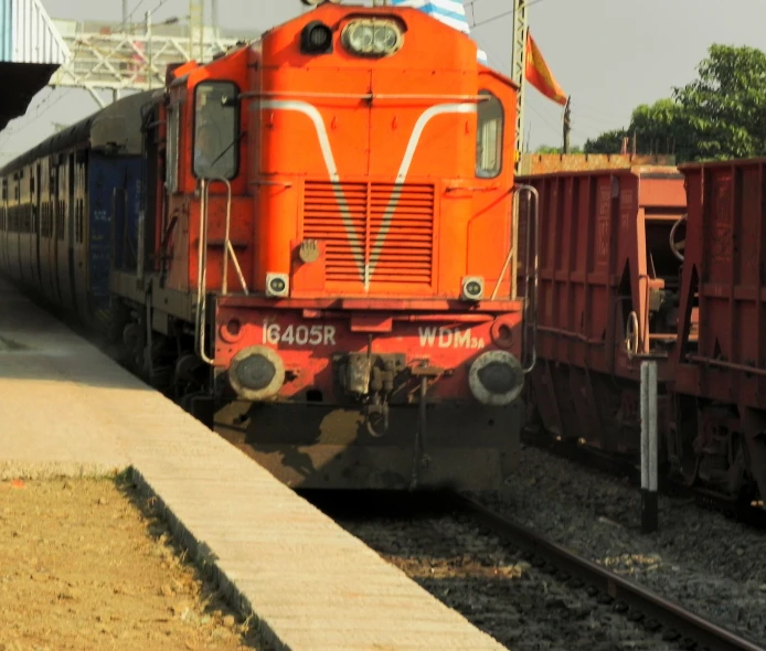 an orange train stopped on railroad tracks
