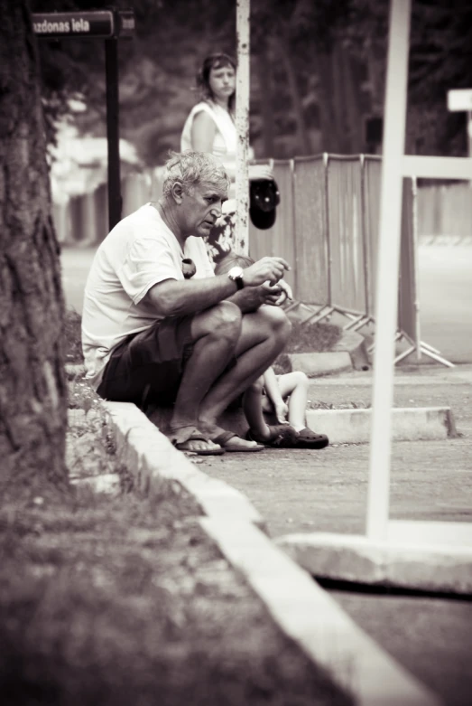 an old man is sitting under a tree and reading