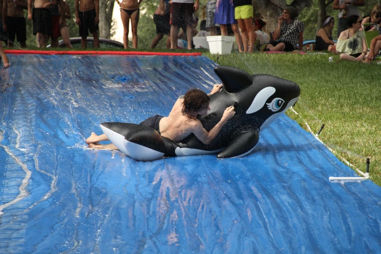 a man sitting on top of an inflatable water slide