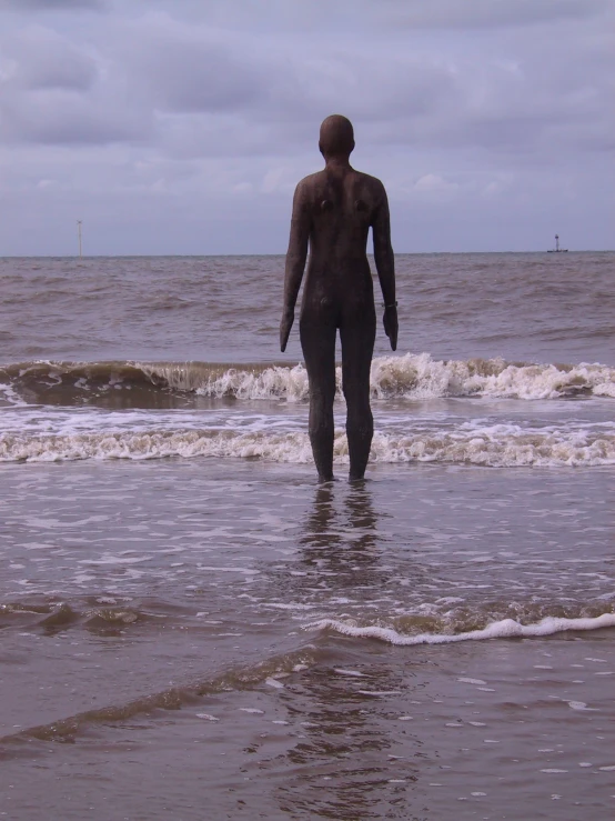 man in wetsuit walking out into the ocean
