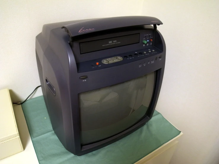 an old computer with an old antenna, on top of a green table