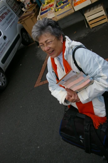an older woman carrying boxes in her backpack