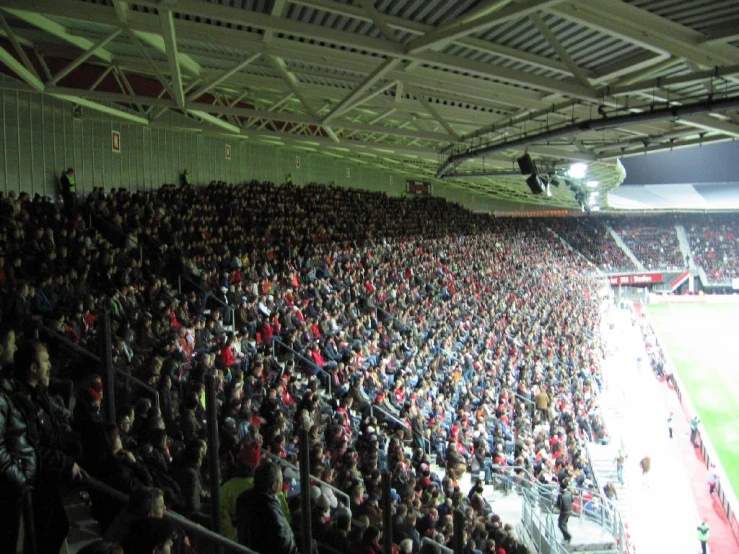 a full stadium with a large crowd at the side