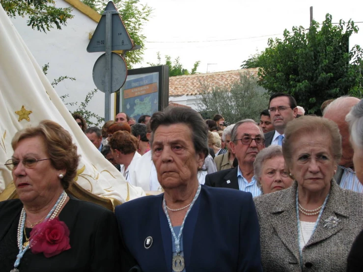a group of older women standing in front of a crowd
