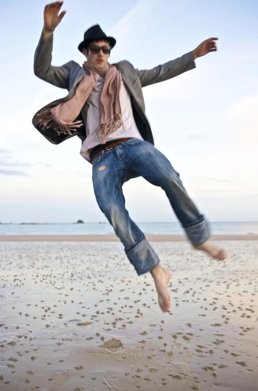 a man jumps in the air on the beach