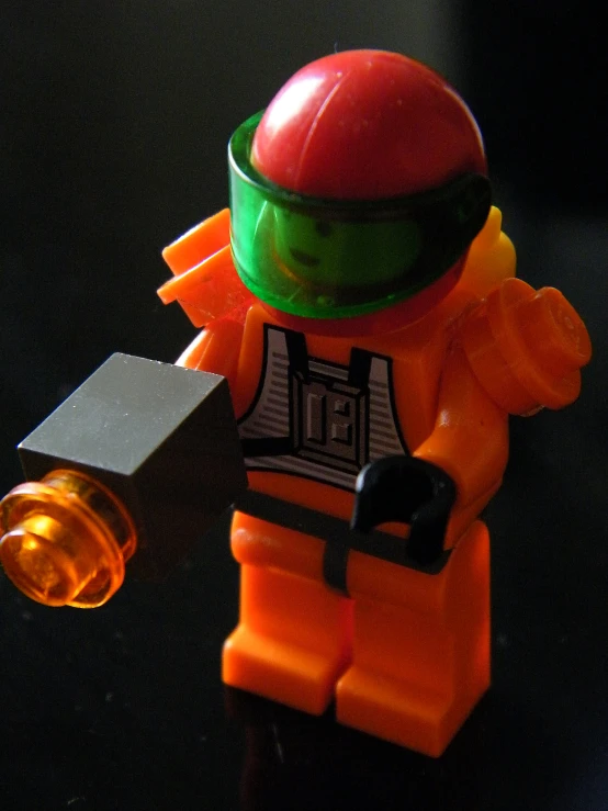 the lego figure in this image is wearing an orange vest and a helmet