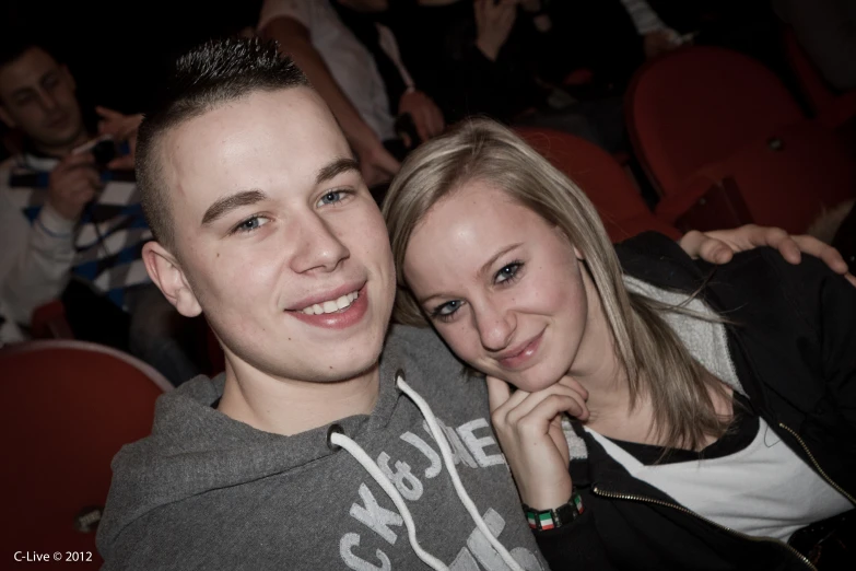 a smiling couple sitting together at a movie theater