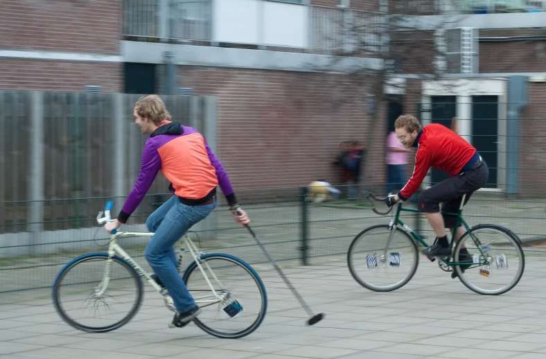 two people are riding bicycles on a paved street