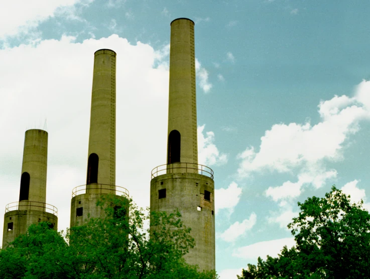 an industrial area with tall chimneys against a blue sky