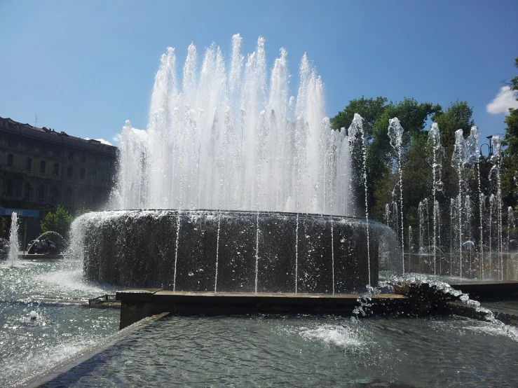 water fountains spewing in the air near a city