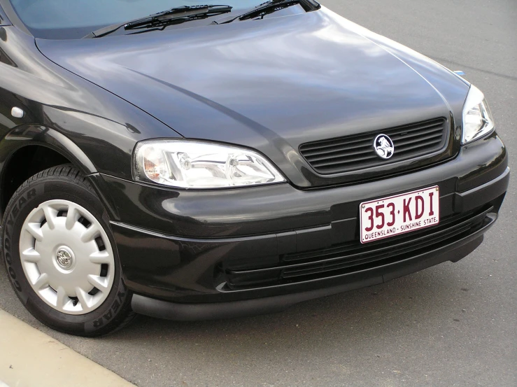 a black car parked on the street with it's license plate