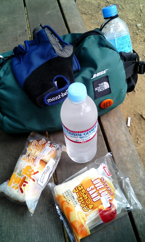 the contents of a backpack are laid out on the picnic table