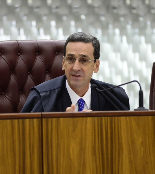 a man sitting in a brown chair speaking