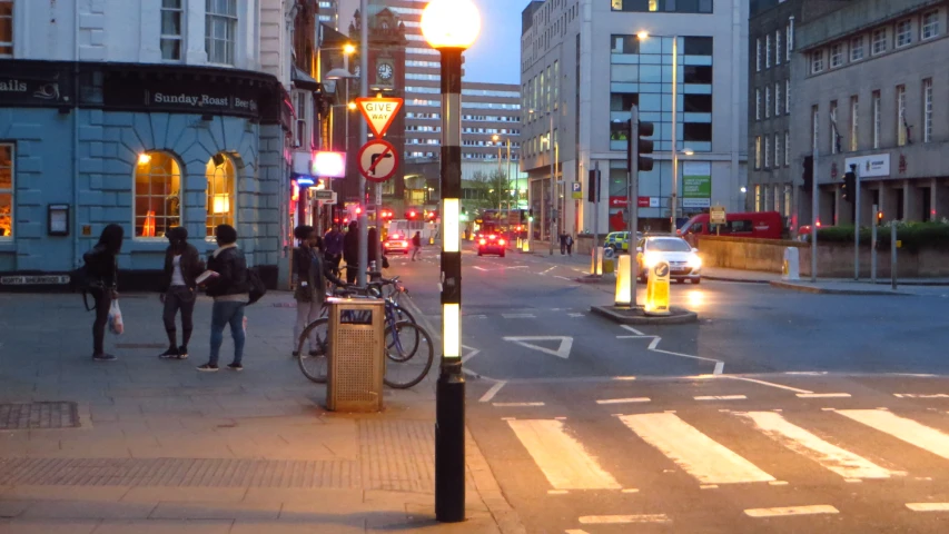 a couple of people standing at a city street corner